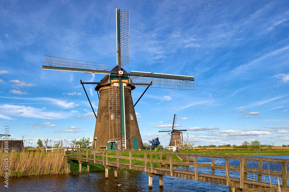 Dutch windmill with a wooden bridge over a canal in Kinderdijk