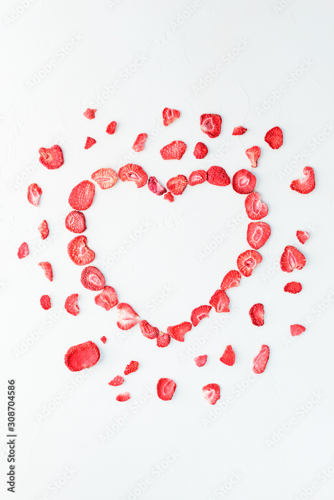 Sublimated strawberry in the form of a heart on a white background. Vertical orientation, copy space. Valentine's Day.