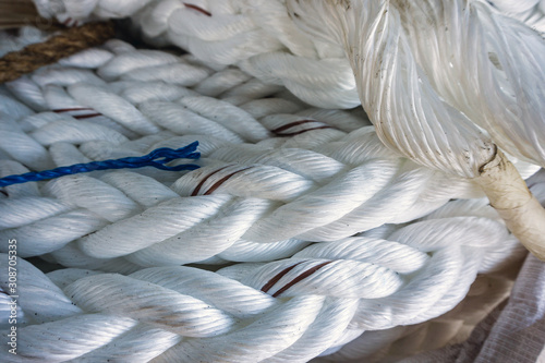 Foto White hawser rope coiled on deck of a construction work barge at oil field