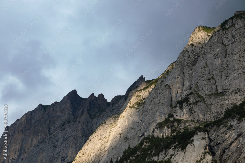 Sunlit rocks on the mountain top. Peaks of the alp at sunset time. Rock formations with sun light. Rocky Mountain detailed close up. Switzerland