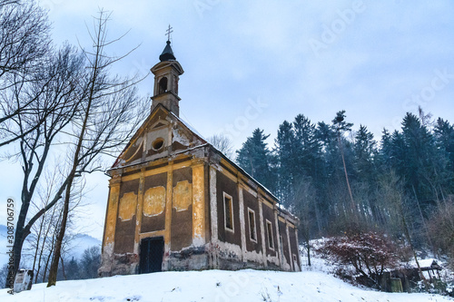 The "Kalvarienberg" church in Bruck/Mur, Styria, Austria surrounded by snow, bare trees and a forest in the background