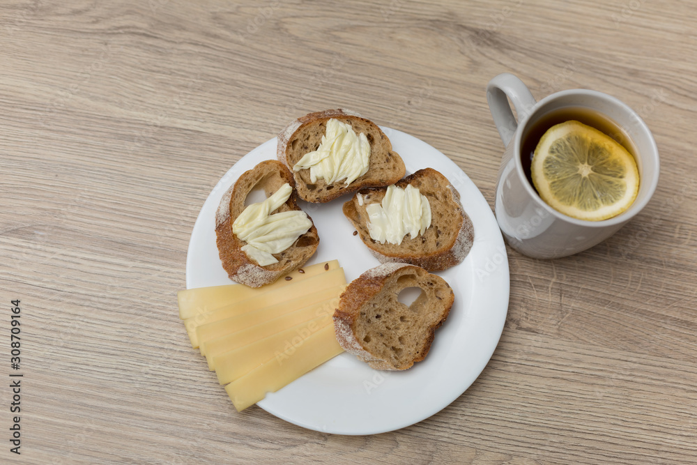 Tea with lemon, sliced bread with cheese and sandwiches Tea with lemon, sliced bread with cheese and sandwiches