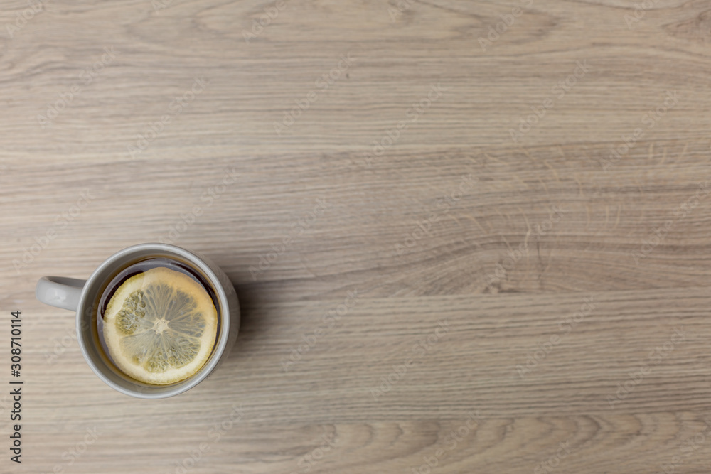 Tea with lemon in a porcelain Cup on a wooden background Tea with lemon in a porcelain Cup on a wooden background