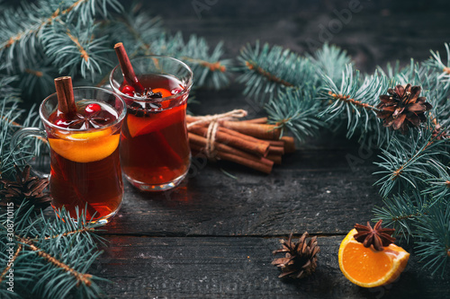 Winter hot drink Christmas mulled wine in glasses with anise, cinnamon and tangerine