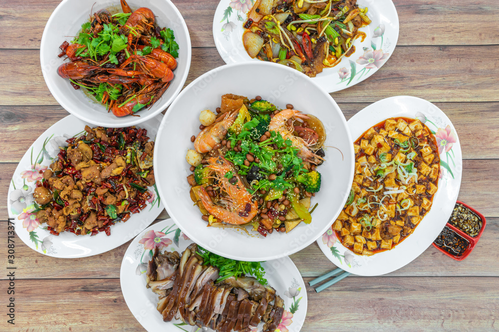 Flat lay top down view of table of authentic China Sichuan Hunan food. Assorted traditional dishes such as Fragrant Hotpot, crispy fried chicken, mini lobsters, spicy bean curd mapo doufu.