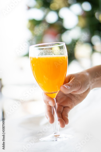 hand holding a glass of orange juice