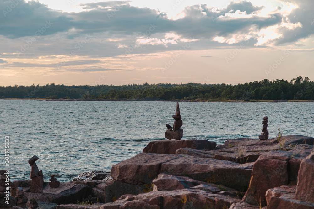 Ancient art of balancing stones, beautiful sunset over the sea