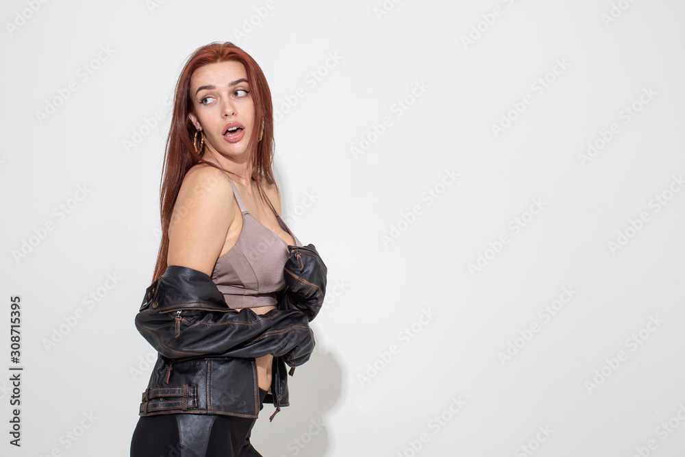 Sexy redhead girl posing in leather jacket on white background Sexy redhead girl posing in leather jacket on white background