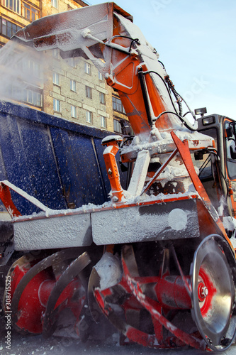 Snowplow cleans snow on city roads closeup. photo