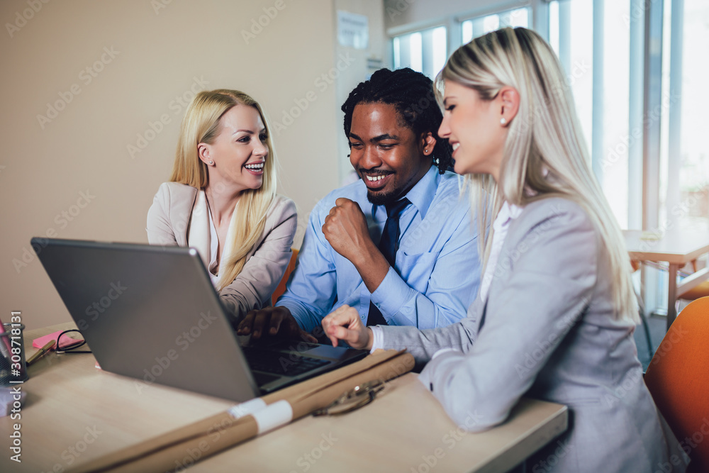 Team of creative people looking at colleague showing project plan on his laptop. Team of creative people looking at colleague showing project plan on his laptop.