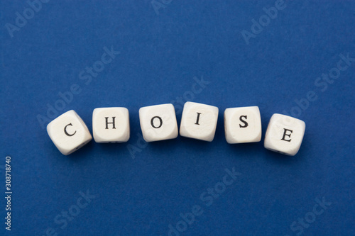 Choise word, lettering written on wooden blocks over blue background.