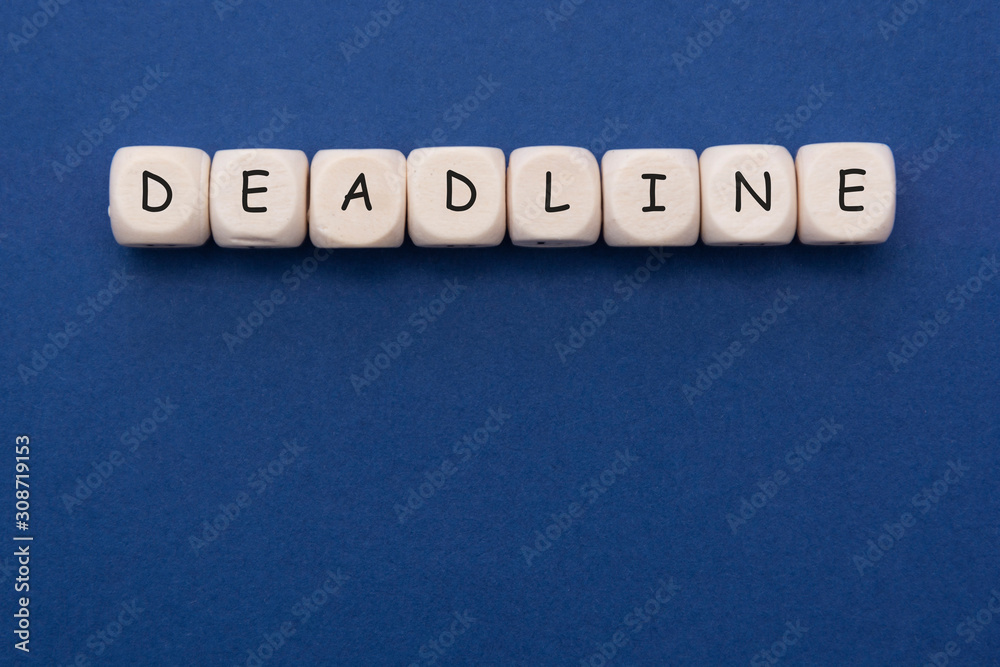 Obraz premium Deadline word on wood blocks over blue background with copy space.
