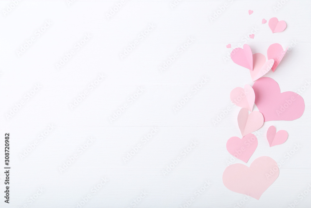 Pink paper hearts on white wooden table