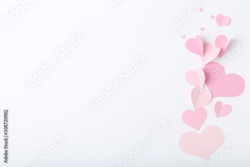 Pink paper hearts on white wooden table