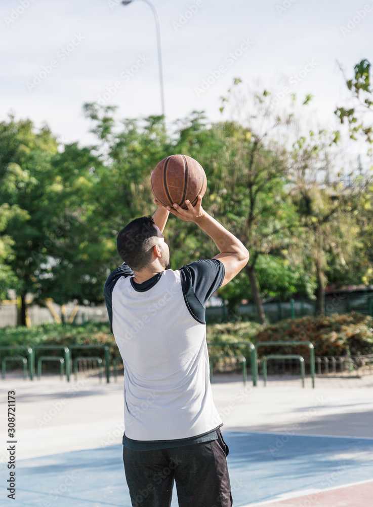 An athlete man with a basketball in his hands, prepares to throw into the basket An athlete man with a basketball in his hands, prepares to throw into the basket