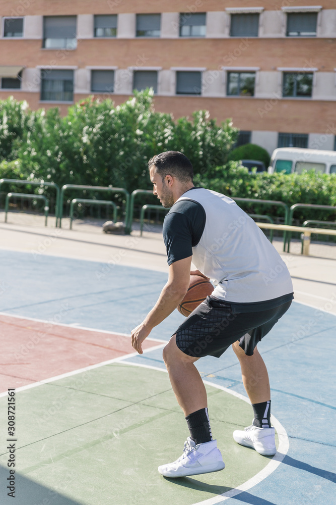 Athlete plays basketball very concentrated to keep track of his ball