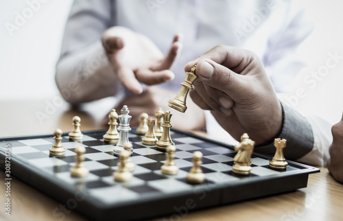 Business men and women analyze chess playing strategies to reduce risks and achieve success, Management or leadership concept.