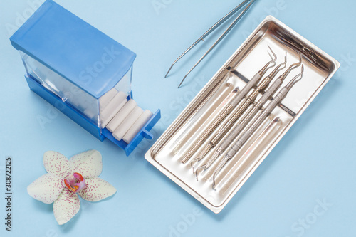 Set of metal dental instruments for teeth dental care and box with tampons