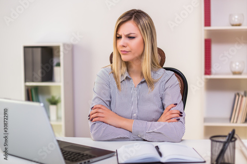 Angry businesswoman sitting in her office and working.