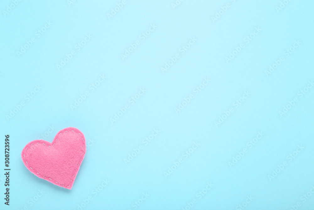 Pink fabric heart on blue background