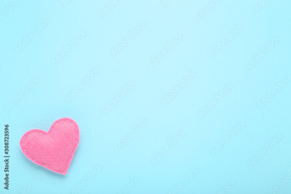Obraz premium Pink fabric heart on blue background
