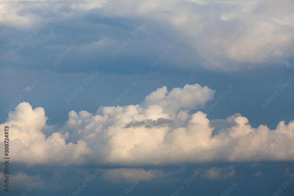 Background of white cumulus clouds on a blue sky at daylight. Telephoto zoom shoot Background of white cumulus clouds on a blue sky at daylight. Telephoto zoom shoot