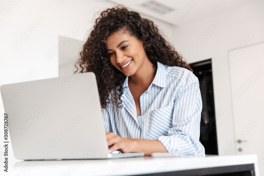 Attractive young african woman working on laptop computer Attractive young african woman working on laptop computer