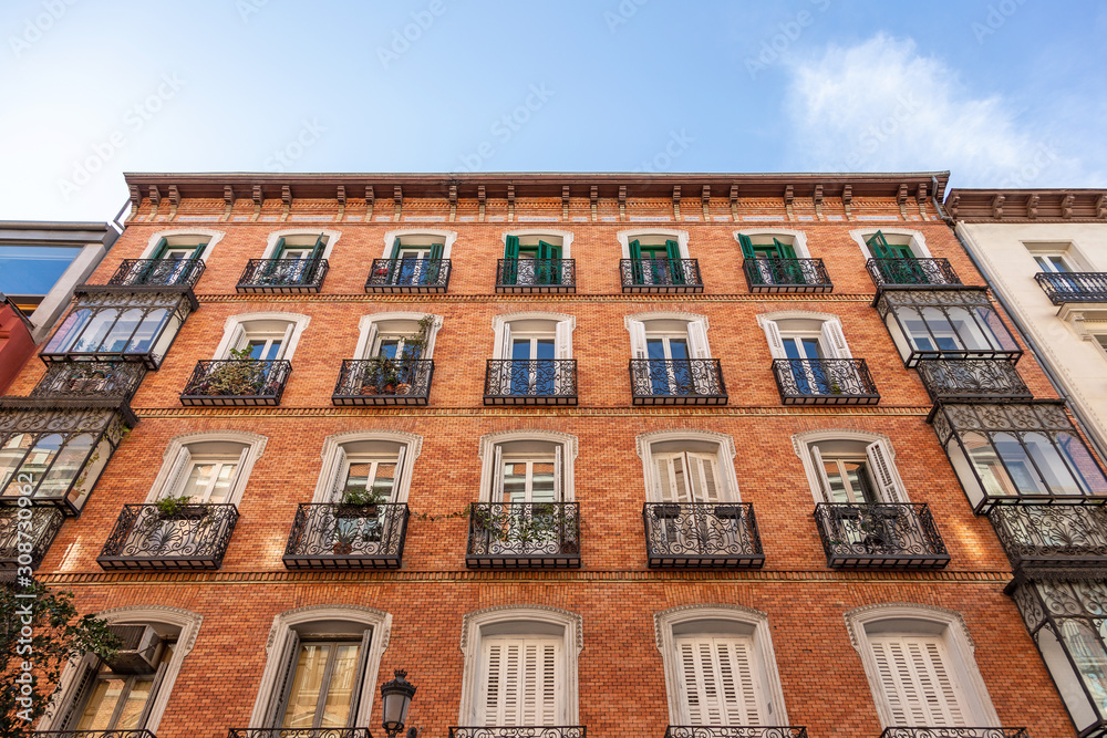 Fototapeta premium beautiful red brick building with cozy balconies