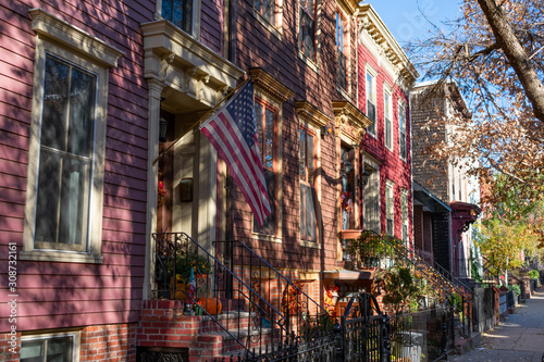 Row of Colorful Old Homes in Greenpoint Brooklyn New York with an American Flag and Sidewalk © James