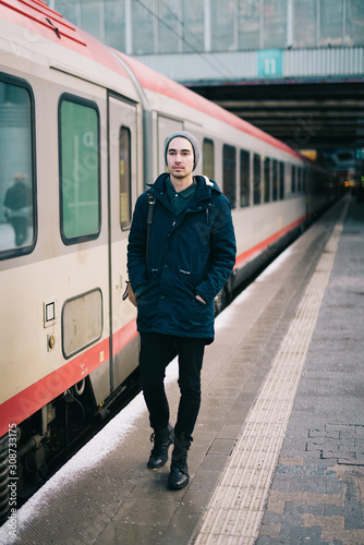 Young man walking by the train