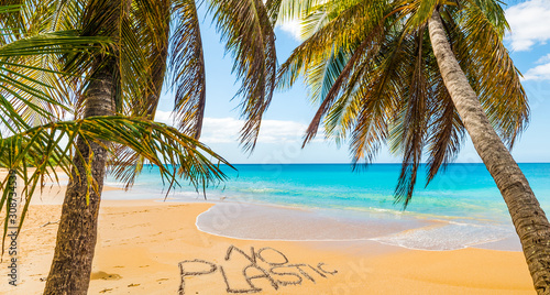 No Plastic written on a beautiful beach