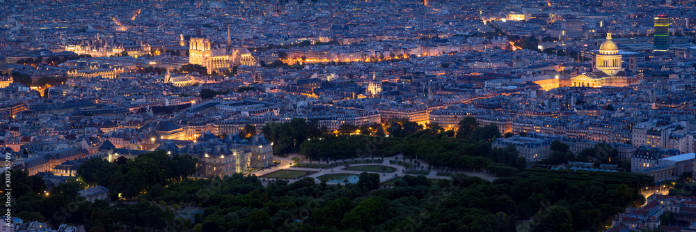 Paris aerial panoramic view at twilight with Luxembourg Gardens, City Hall, illuminated Notre-Dame de Paris Cathedral and the Pantheon. Paris rooftops of the 4th, 5th and 6th Arrondissements. France