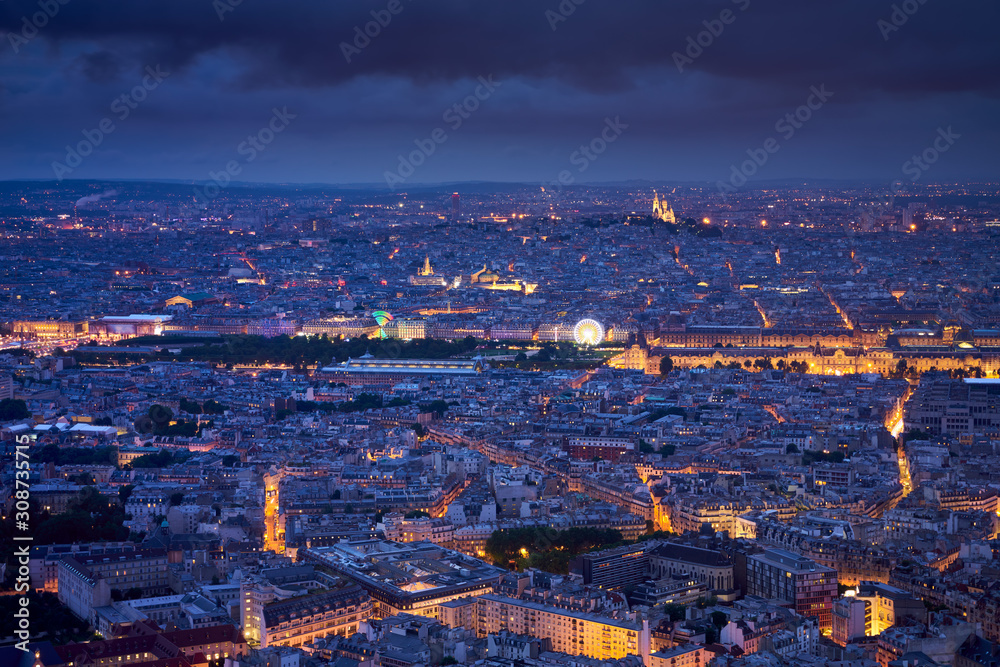 Paris aerial view at twilight with the Jardins des Tuileries, Le Louvre and Montmartre Sacré-Coeur. Rooftops of Paris, 1st, 7th and 18th Arrondissements. France