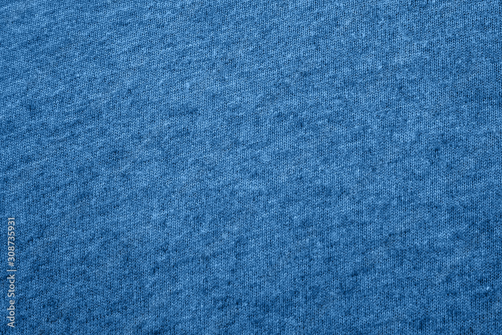 The texture of a knitted woolen fabric in classic blue trendy color. background. Color of the year 2020. The texture of a knitted woolen fabric in classic blue trendy color. background. Color of the year 2020.
