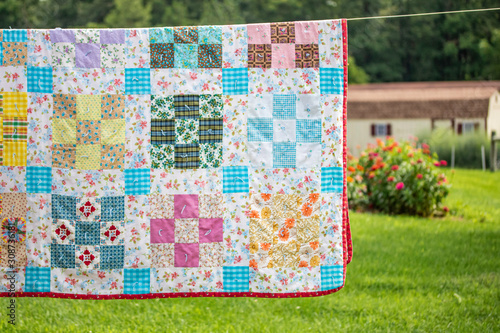 Handmade Quilt Airing on Line By a Flower Garden