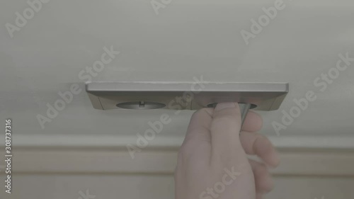 Caucasian man plugs in powerplug in wall close-up 4k photo