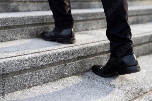 modern businessman working close-up legs walking up the stairs in modern city. in rush hour to work in office a hurry. During the first morning of work. stairway. soft focus.