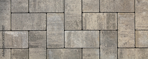 Regular shape blocks, texture, background. Paving slabs of gray blocks of flat shape, close-up. New pavement in the city park. Arrangement of a park way