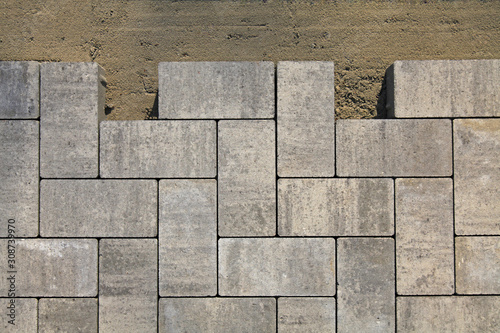 Regular shape blocks, texture, background. Paving slabs of gray blocks of flat shape, close-up. Fragment of the laying of new paving slabs. Arrangement of a park way