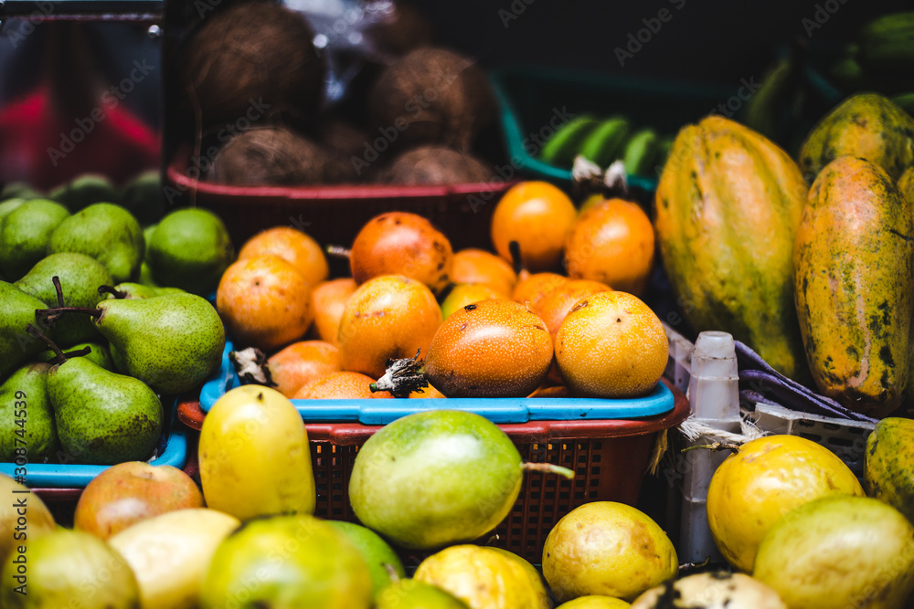 Baskets of exotic Colombian fruits on sale at a food market stall | Juicy granadilla passion fruit, curuba, guanabana, coconuts, pears and lulo