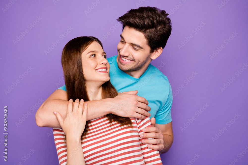 Photo of two adorable guy lady people couple hugging piggyback charming looking eyes hold arms wear casual blue striped t-shirts isolated purple color background