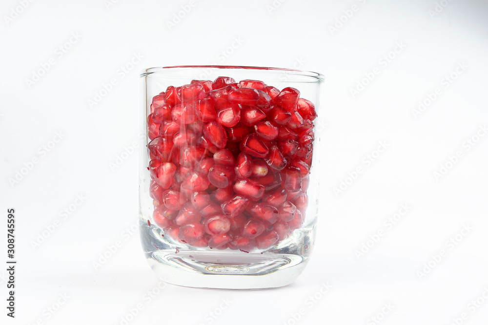 Red Pomegranate seed in glass on white background Red Pomegranate seed in glass on white background