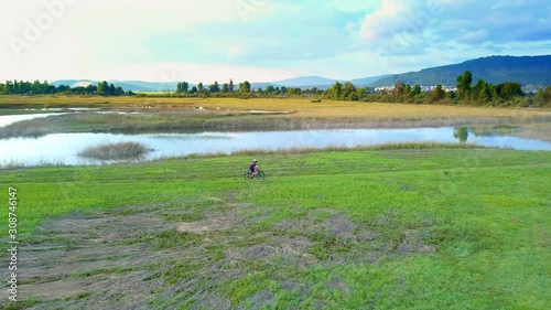 Two Cyclists Ride Off Road Path Around Lake Cernika