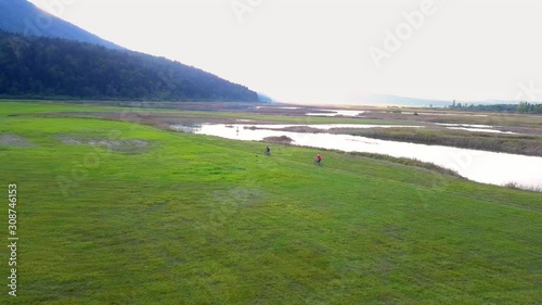 Cyclists Ride Off Road Trail Around Lake Cernika