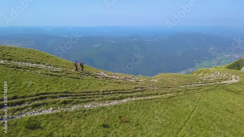 Couple hiking and exploring karst wonders of Nanos plateau, aerial shot photo