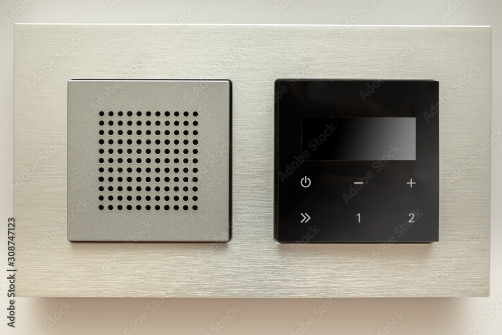 Multifunction outlet with speaker and touchpad on a wall. Multifunction outlet with speaker and touchpad on a wall.