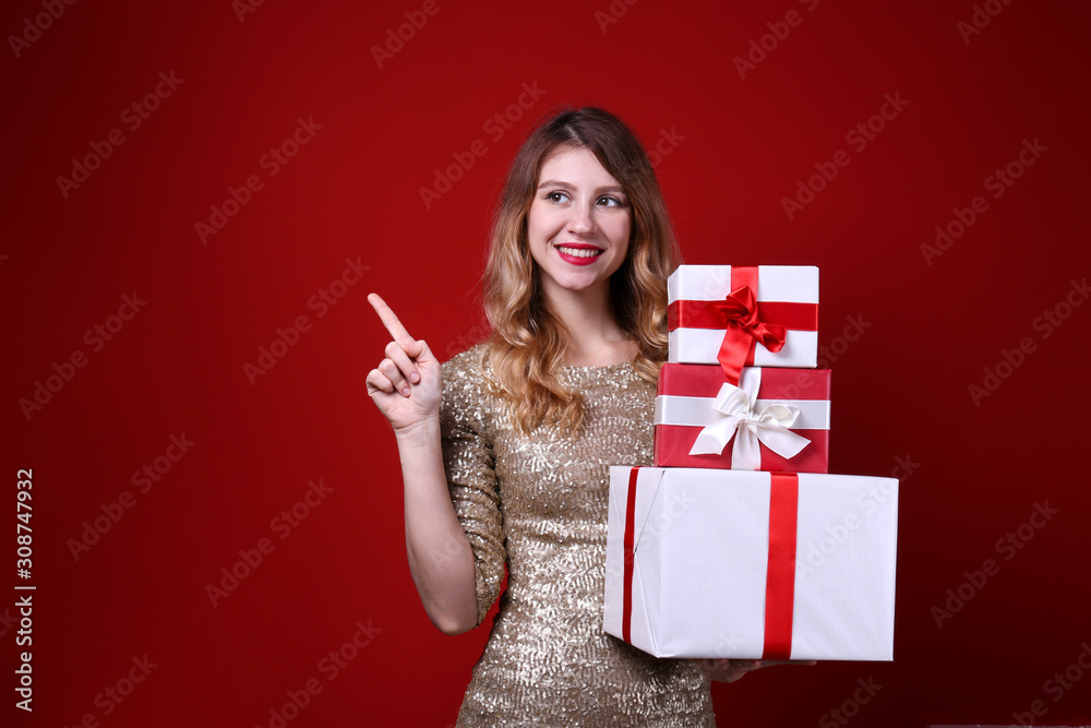 Studio shot of beautiful smiling young woman wearing sexy gold sequin dress for Christmas party. Attractive blonde female posing over red wall, new years eve. Copy space, isolated background, close up Studio shot of beautiful smiling young woman wearing sexy gold sequin dress for Christmas party. Attractive blonde female posing over red wall, new years eve. Copy space, isolated background, close up
