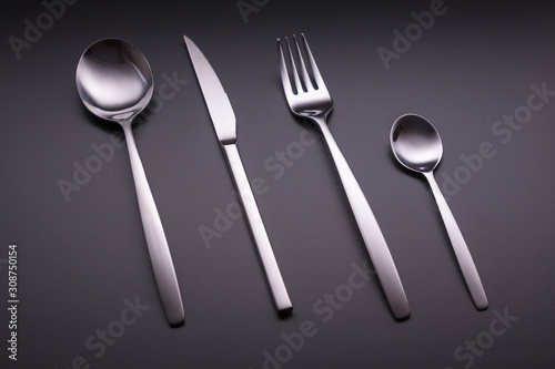 Shiny cutlery over a black background