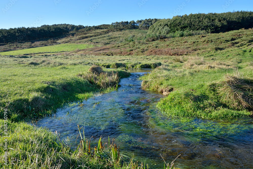  Stream that ends on the beach of Moreira, Muxía, Galicia, Spain. These small streams are typical on the wild beaches of the Galician Atlantic, sometimes forming small lagoons.