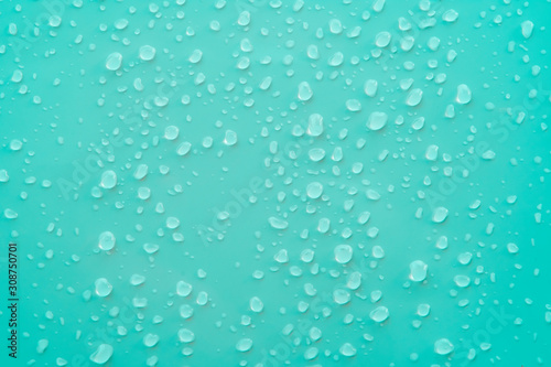 pure water drop above surface of ocean cyan color background